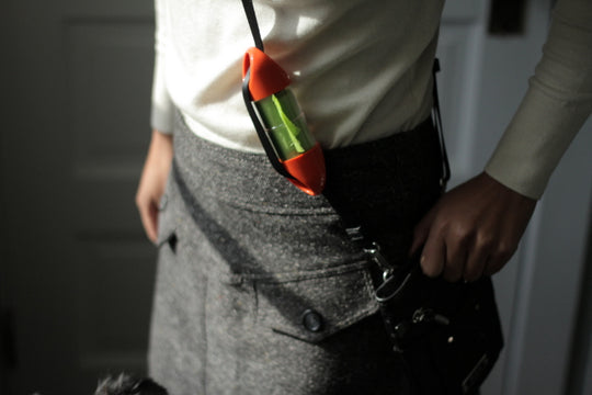 Orange LOOP poop bag holder on handbag strap.#color_orange