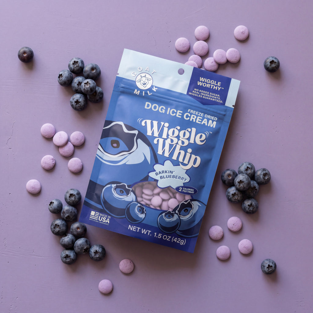 Wiggle Whip Freeze-Dried Dog ice cream package with blueberries and pink treats on a lavender background